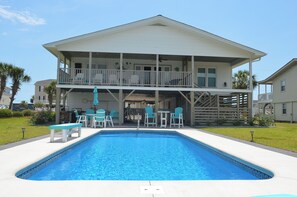 A two-story house with a pool, outdoor seating, and a covered patio area. - Kick's Kids - Channelfront in Garden City Beach! (Garden City Beach)