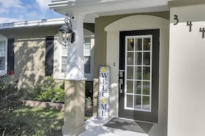 Welcome to a charming home with a white door, glass panel, and a cozy porch.