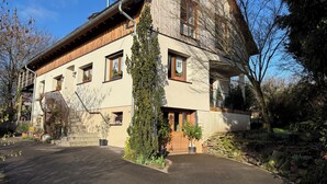Un bâtiment à deux étages doté d’une façade en bois, d’un escalier en pierre et d’une allée pavée.