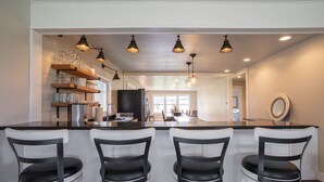 A modern kitchen with a central island, bar stools, and pendant lighting. - 3/2 home 20 minutes from Glacier National Park, Sleeps 8! (Columbia Falls)