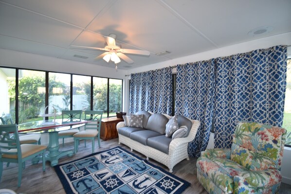A living room with a sofa, chairs, a coffee table, and a patterned rug.