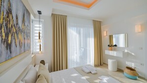 A modern hotel room with a large bed, a bedside table, a mirror, and a painting on the wall. - Villa Ucar C Peacefull 4 bed villa with pool for rent in Ovacık oludeniz (Mugla)