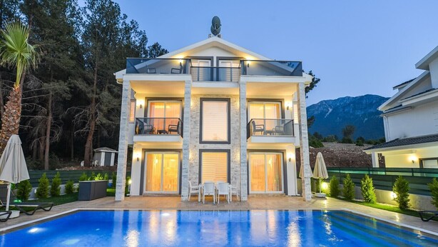 A two-story house with a swimming pool in front, surrounded by trees and a mountain in the background. - Villa Ucar C Peacefull 4 bed villa with pool for rent in Ovacık oludeniz (Mugla)