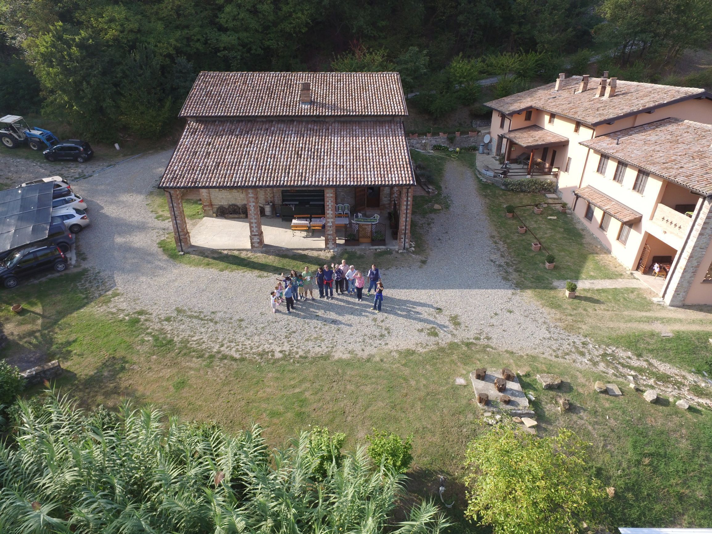 Un bâtiment doté d’un toit en tuiles, d’un patio couvert et d’une cour en gravier.