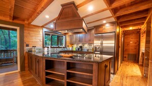 Une cuisine spacieuse avec des meubles en bois, un grand îlot central et un four encastré.
