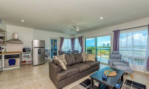 A modern living room with a sofa, coffee table, and a view of the ocean.