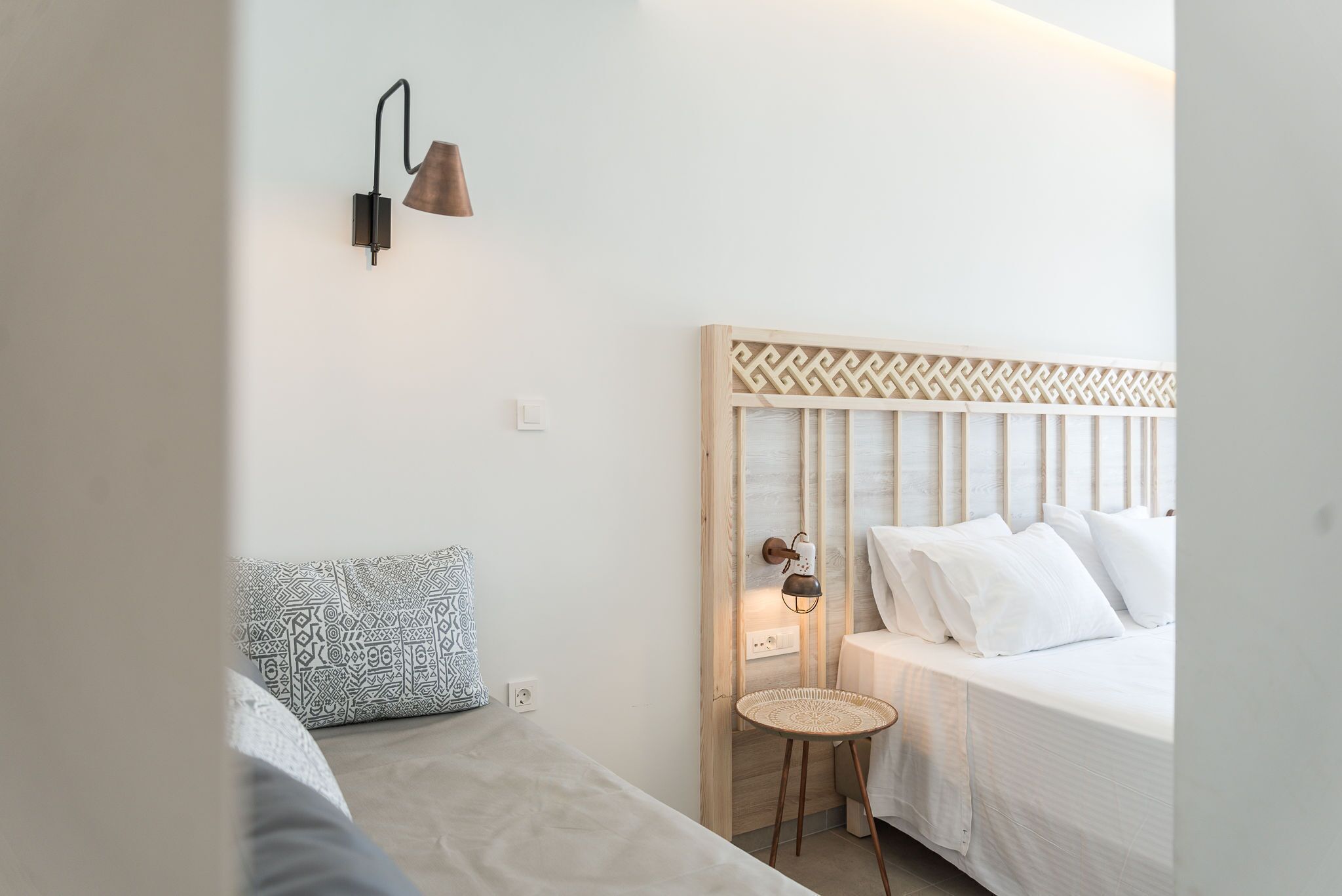 Une chambre à coucher avec un lit, une table de chevet, une lampe et un coussin à motifs.