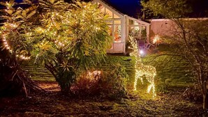 A house with a glass facade, surrounded by illuminated trees and a pond. - 'The Willows' A Charming home on Dollarbeg Castle Estate (Dollar)