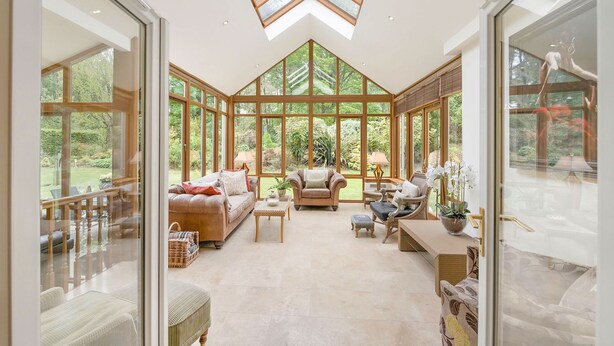 A conservatory with a high ceiling, large windows, and a variety of seating arrangements. - 'The Willows' A Charming home on Dollarbeg Castle Estate (Dollar)