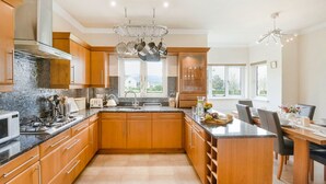 A modern kitchen with wooden cabinets, a central island, and a dining area with a view. - 'The Willows' A Charming home on Dollarbeg Castle Estate (Dollar)