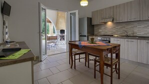 Une cuisine moderne avec des meubles en bois, une table à manger avec des chaises et une grande fenêtre.