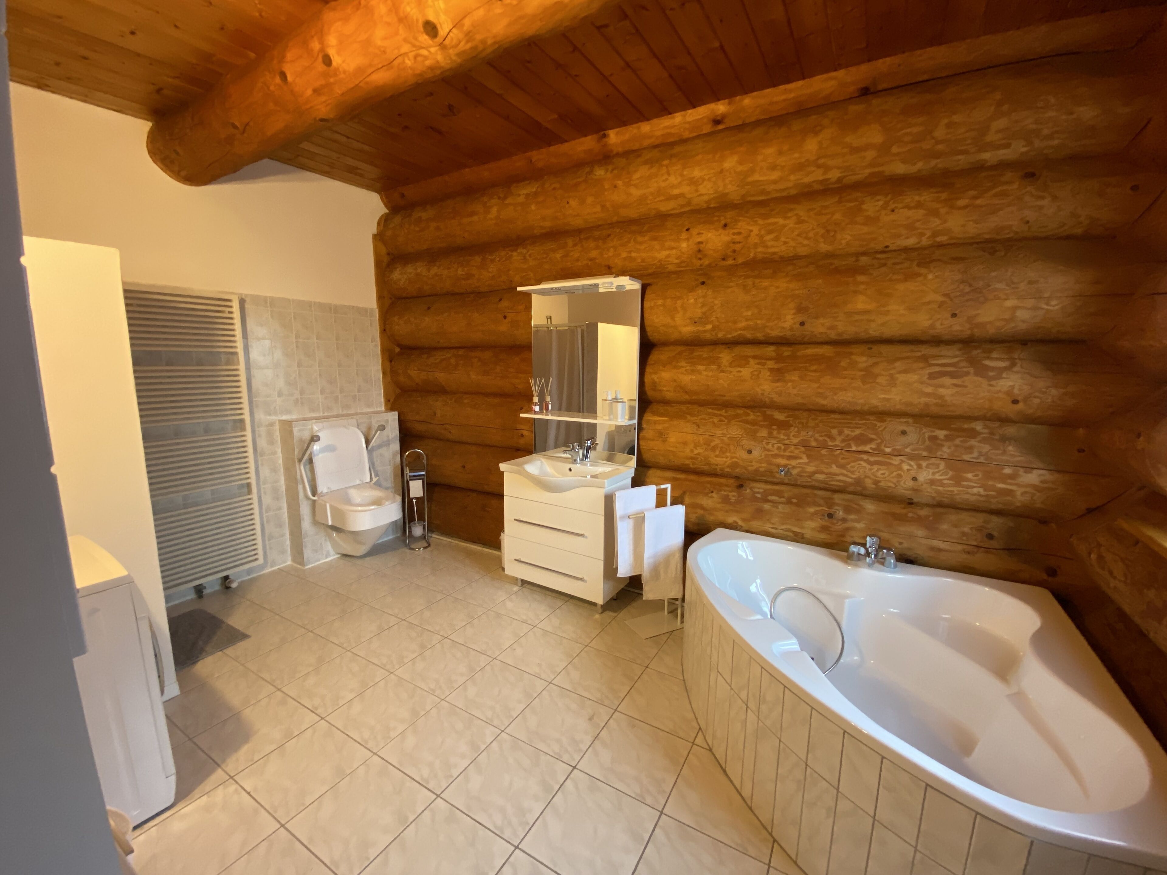 A log cabin bathroom with a toilet, sink, and bathtub.