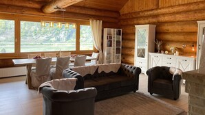 Ein rustikales Blockhaus mit Essbereich, einer Couch und einem Schrank.