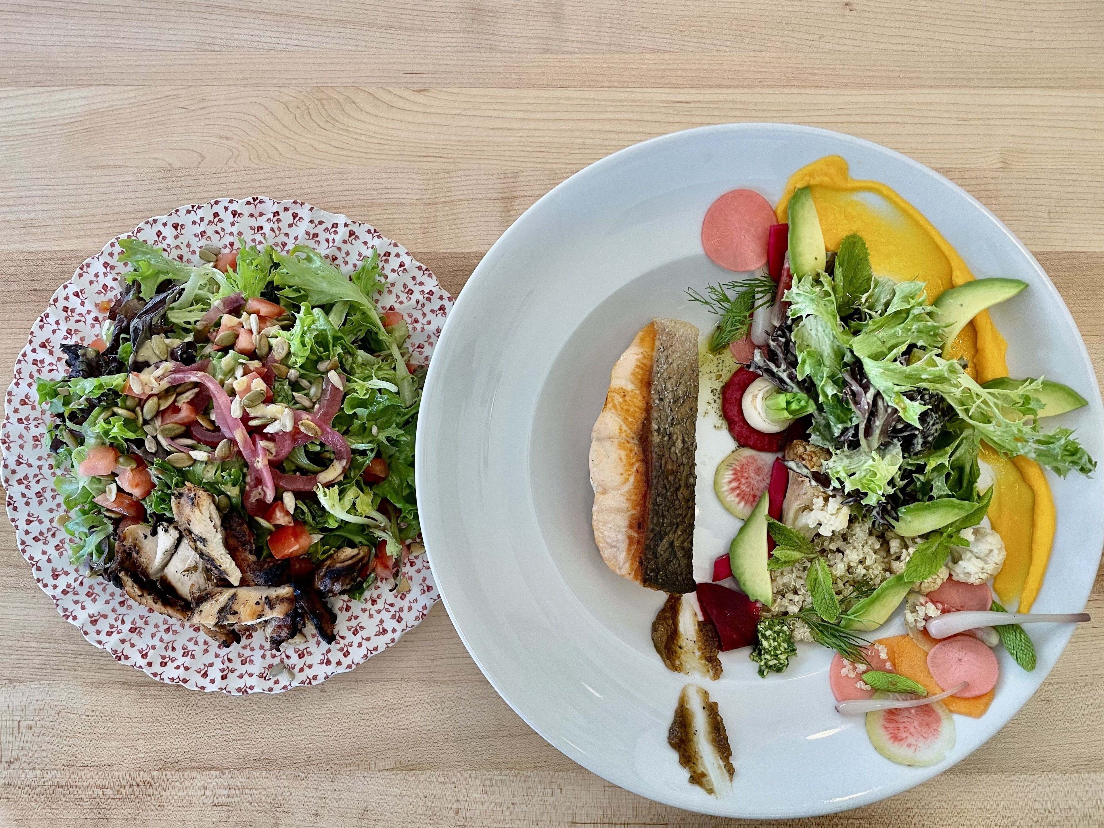 Duas porções de comida sobre uma mesa de madeira.