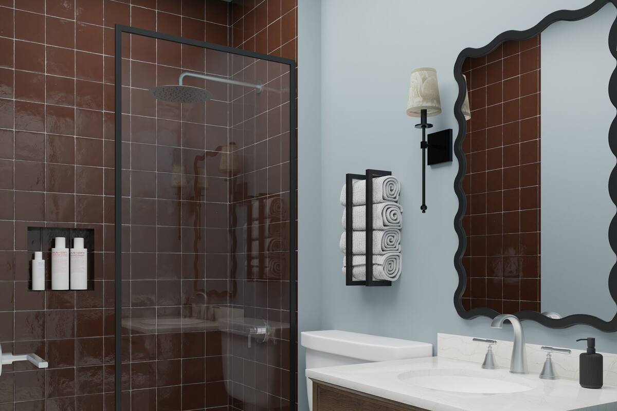 A modern bathroom with a glass-enclosed shower, a white toilet, a wooden vanity with a sink, and a mirror with a unique frame.