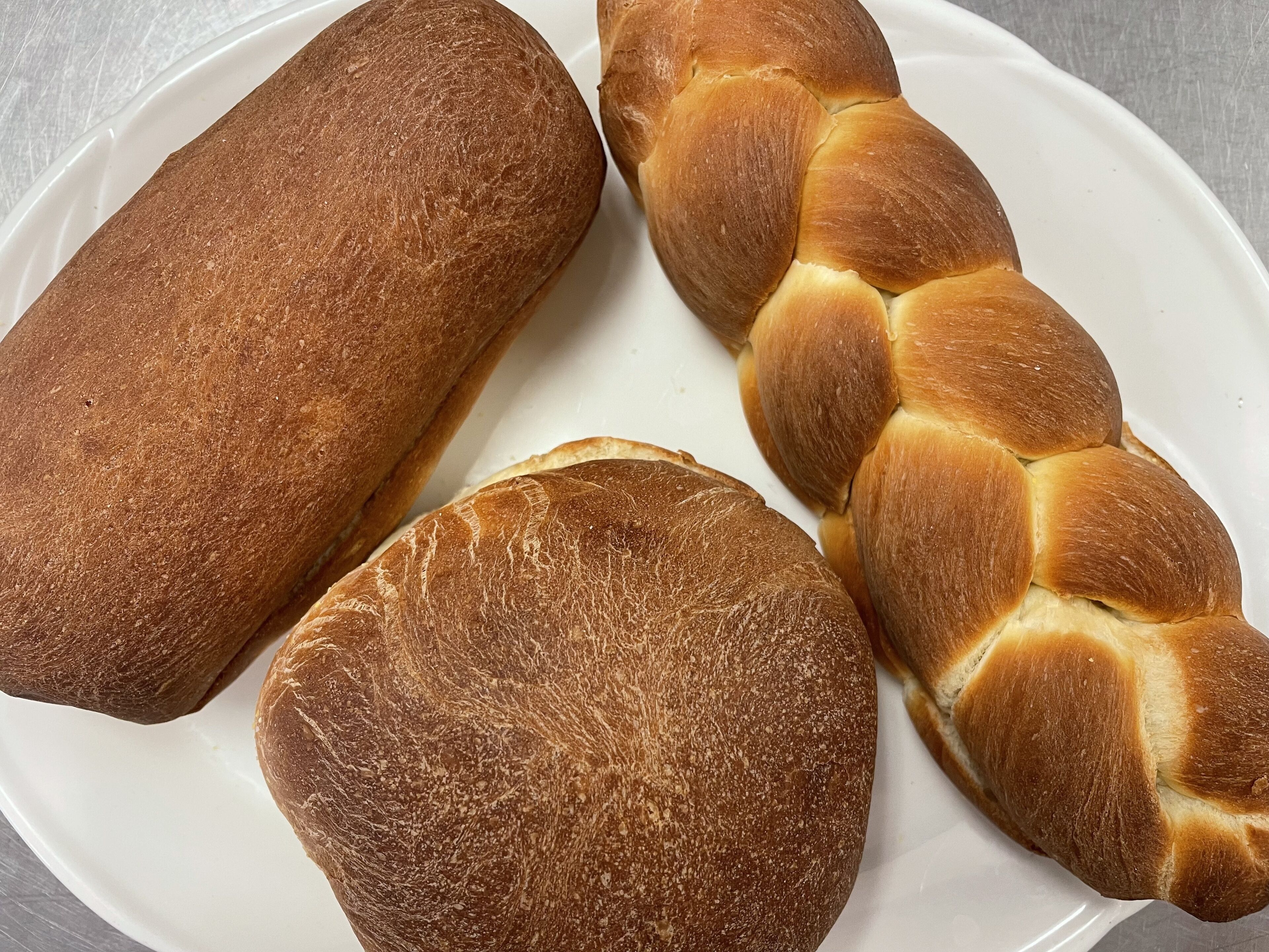 Tres hogazas de pan sobre un plato blanco.