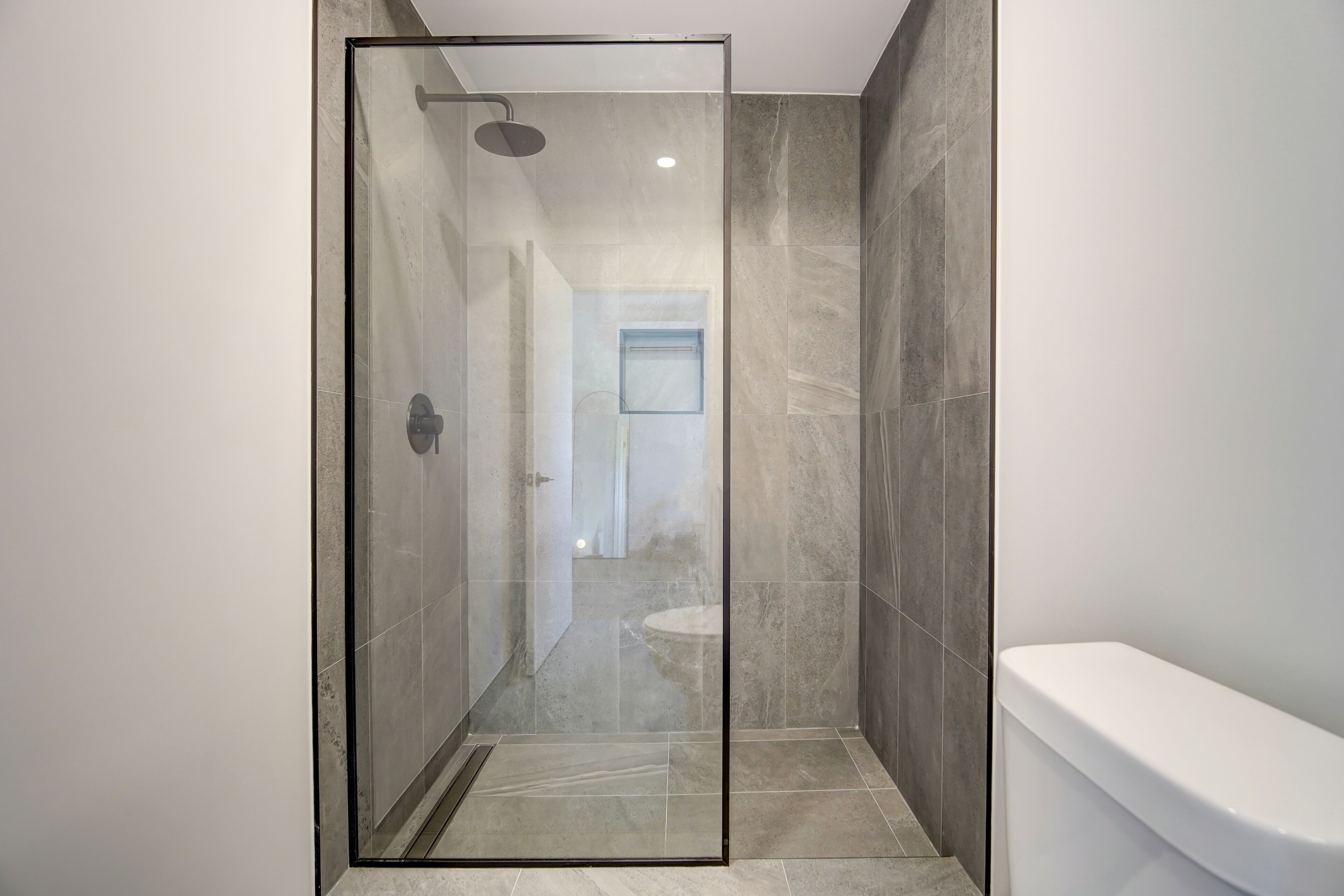 Un baño moderno con ducha de vidrio, inodoro y bañera.