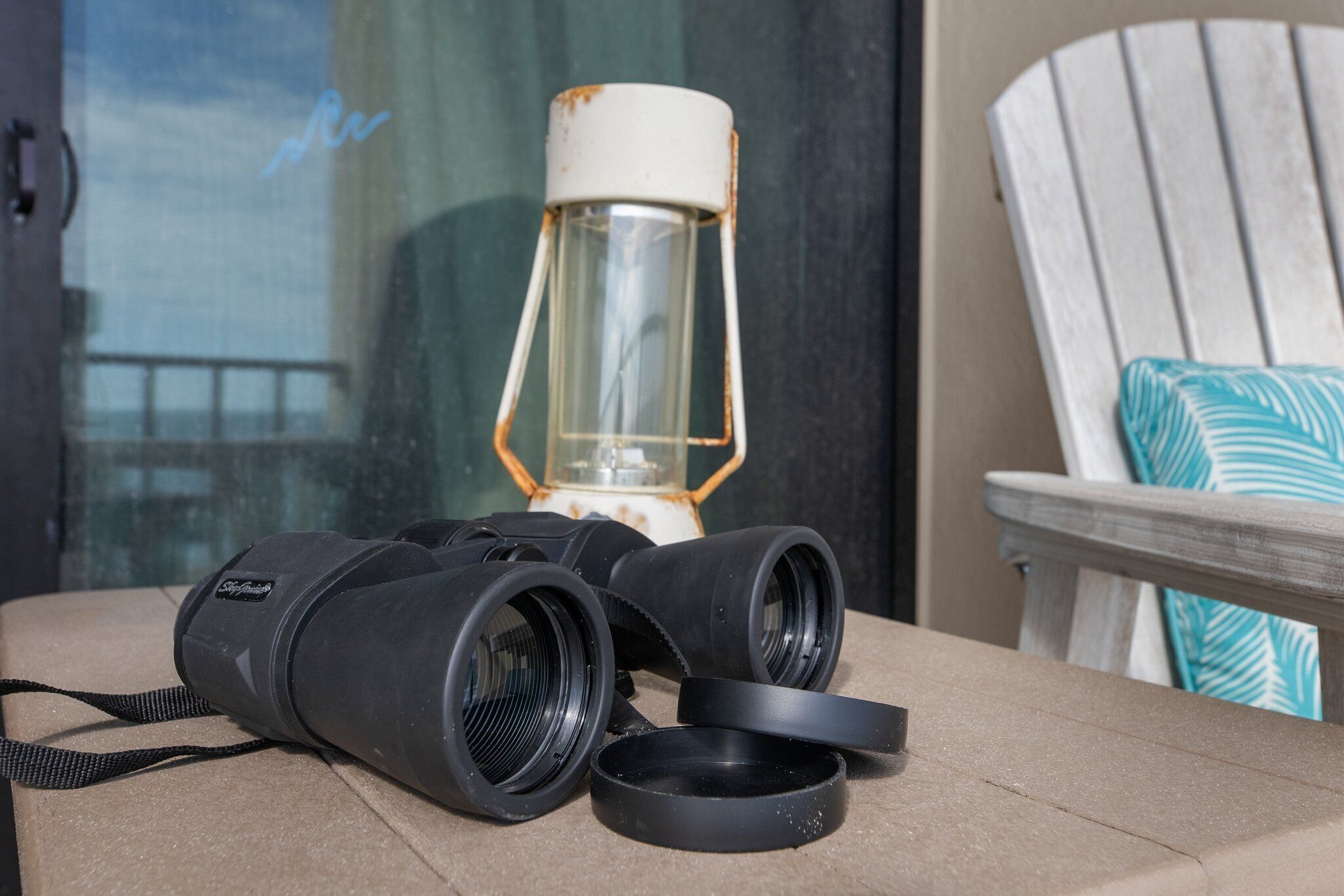 Binoculars, a lantern, and a chair with a cushion.