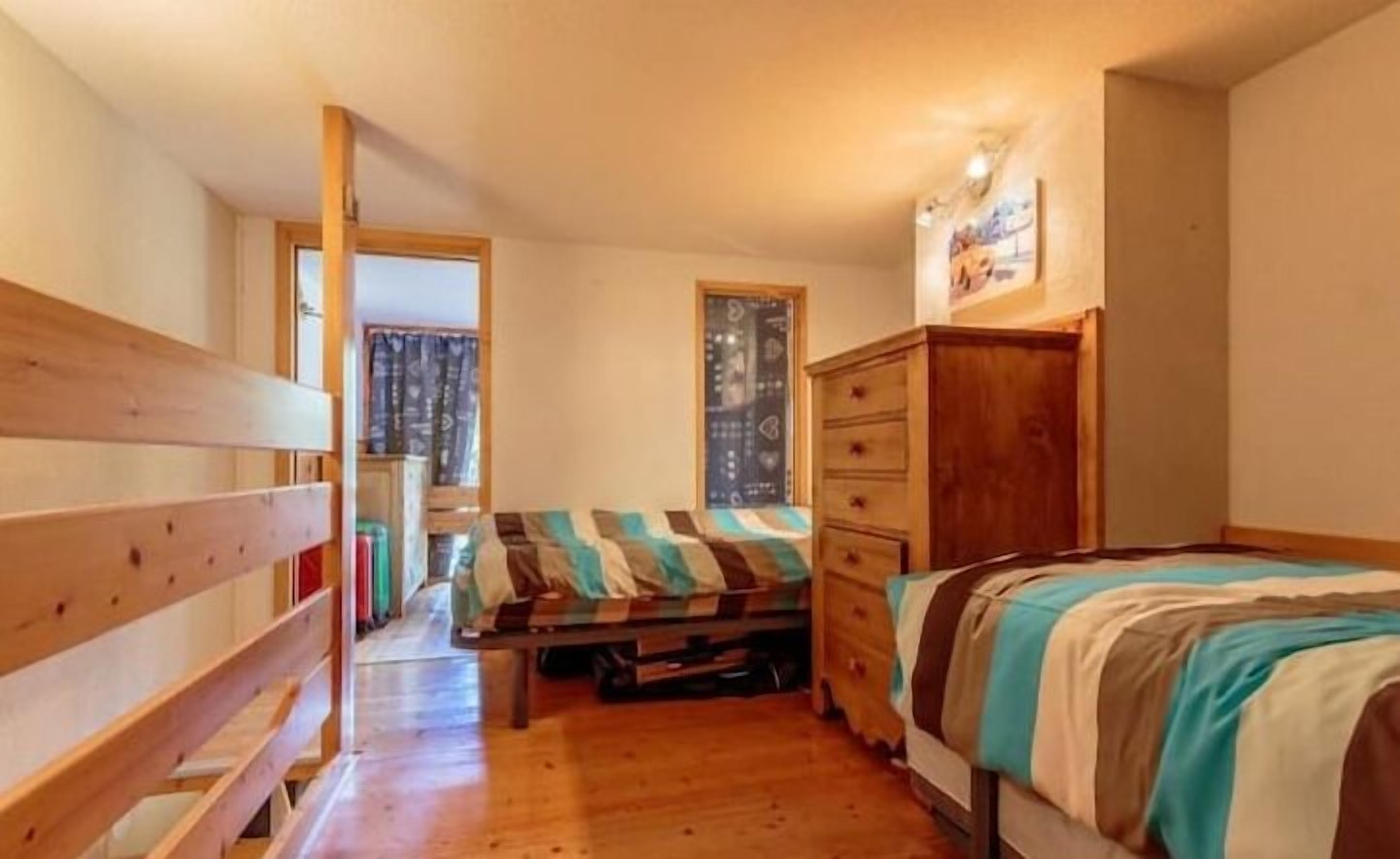 Ein Schlafzimmer mit einem hölzernen Bett, einem Schminktisch und einem Fenster.