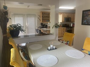 Enjoy meals in this cozy dining area with a table set for four, featuring a kitchenette and comfortable seating.