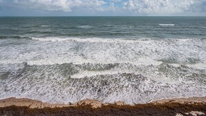 Une plage avec des vagues et un ciel dégagé.