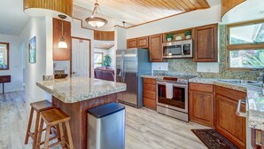 Una cocina moderna con armarios de madera, electrodomésticos de acero inoxidable y una encimera de granito.