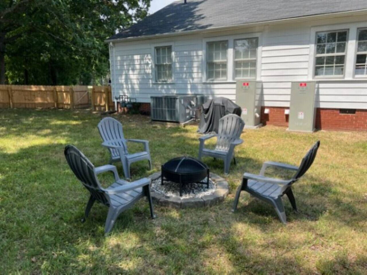 Quintal com lareira e quatro cadeiras Adirondack.