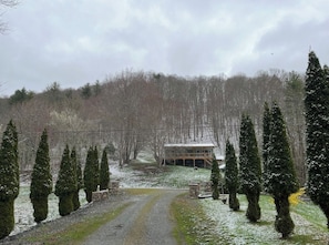 A house with a porch, surrounded by snow-covered trees and a gravel driveway. - Mountain Getaway | Fire Pit, Mtn Scenery, Stars (Mars Hill)