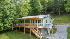A two-story house with a covered porch and a staircase leading to the upper level. - 4 BR ~ 4 Mins to Hatley Pointe ~ Fall Mtn Views (Mars Hill)
