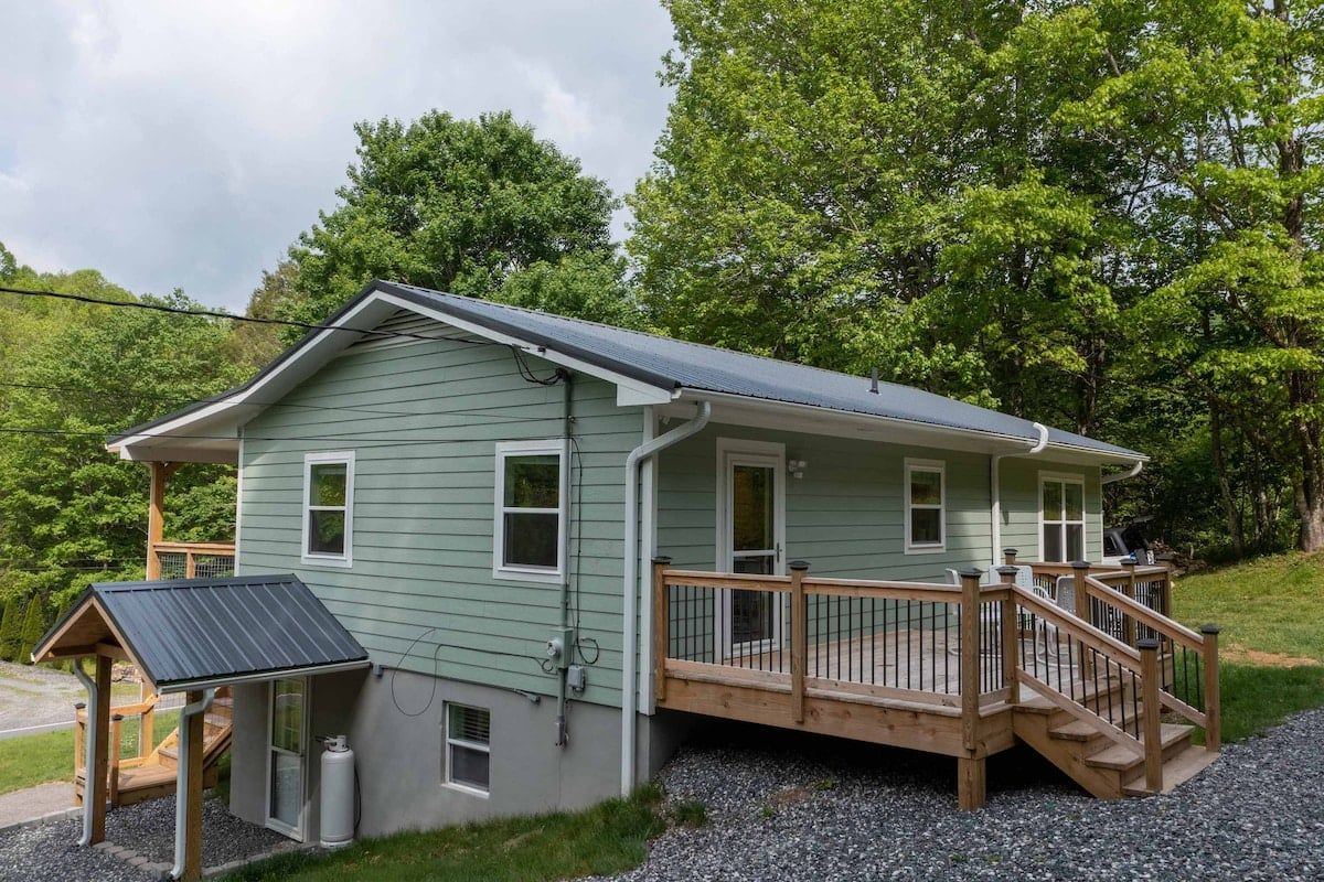 A two-story house with a deck and a covered porch.