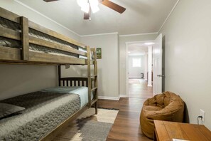 A room with bunk beds, a bean bag chair, and a small table.