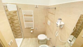 Une salle de bain équipée de toilettes, d’un bidet et d’un lavabo.