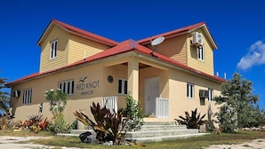 A two-story building with a red roof and beige walls, labeled "Red Knot Manor."