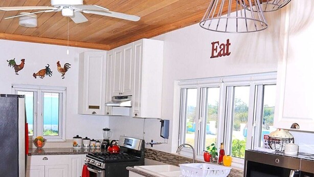 A modern kitchen with white cabinets, stainless steel appliances, and a granite countertop.