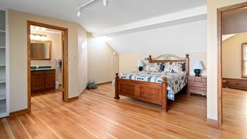 A bedroom with a wooden bed, a nightstand, a dresser, and a walk-in closet.