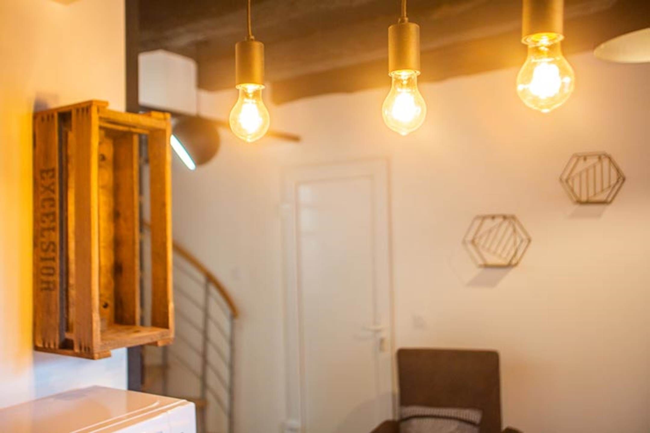 A room with a wooden cabinet, a door, and two hexagonal wall decorations.