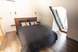 A bedroom with a bed, wooden headboard, and a nightstand. - ★Stunning industrial-style duplex★ for 2 people (Montignac)