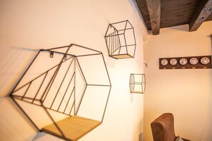 A room with geometric wall art and a wooden chair.