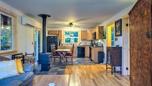 A spacious kitchen with wooden cabinets, a dining area with a table and chairs, and a large window providing natural light.