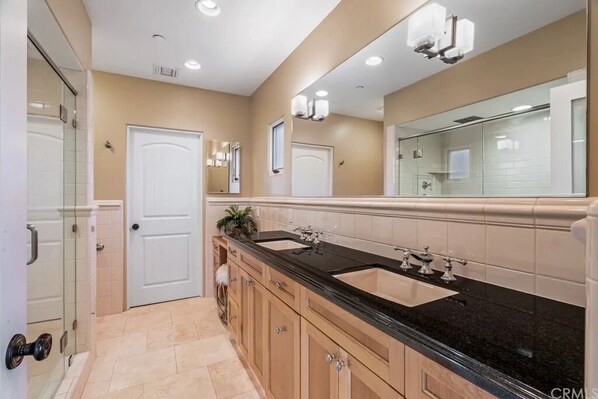 A modern bathroom with a double sink, vanity, and a large mirror. - Mandalay Shores Townhome (oxnard)