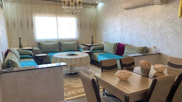 A living room with a sofa set, a dining table, and a chandelier. - Beautiful, luxurious and very quiet apartment. (Marrakech)
