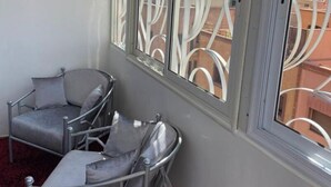 A room with two grey armchairs and a window with decorative white metal framing. - Beautiful, luxurious and very quiet apartment. (Marrakech)