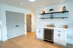 Kitchen features white cabinetry, stainless steel appliances, and a wooden floor.