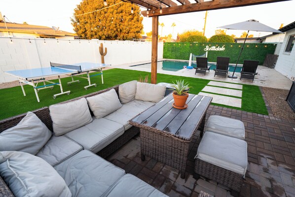 Relax in style with a comfortable seating area, ping pong table, and lush lawn.