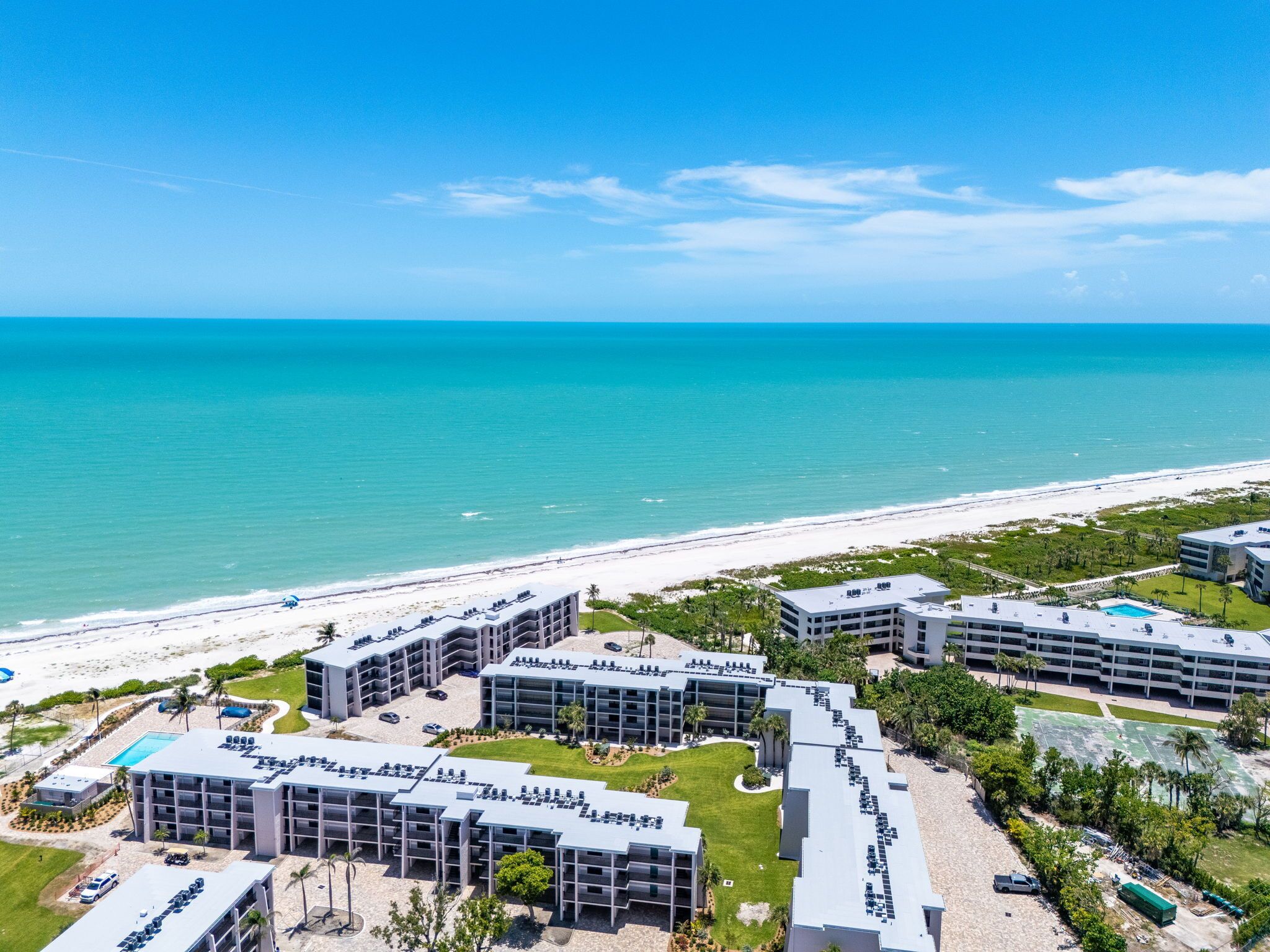 Un hôtel situé sur la côte, composé de plusieurs bâtiments, doté d’une plage et offrant une vue dégagée sur l’océan.
