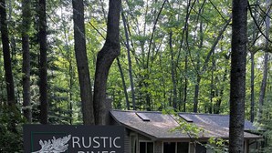 A rustic cabin labeled "Rustic Pines 540" surrounded by a forest. - Rustic Pines - Woods, Water and Nature to Relax & Unwind. (Harrison)