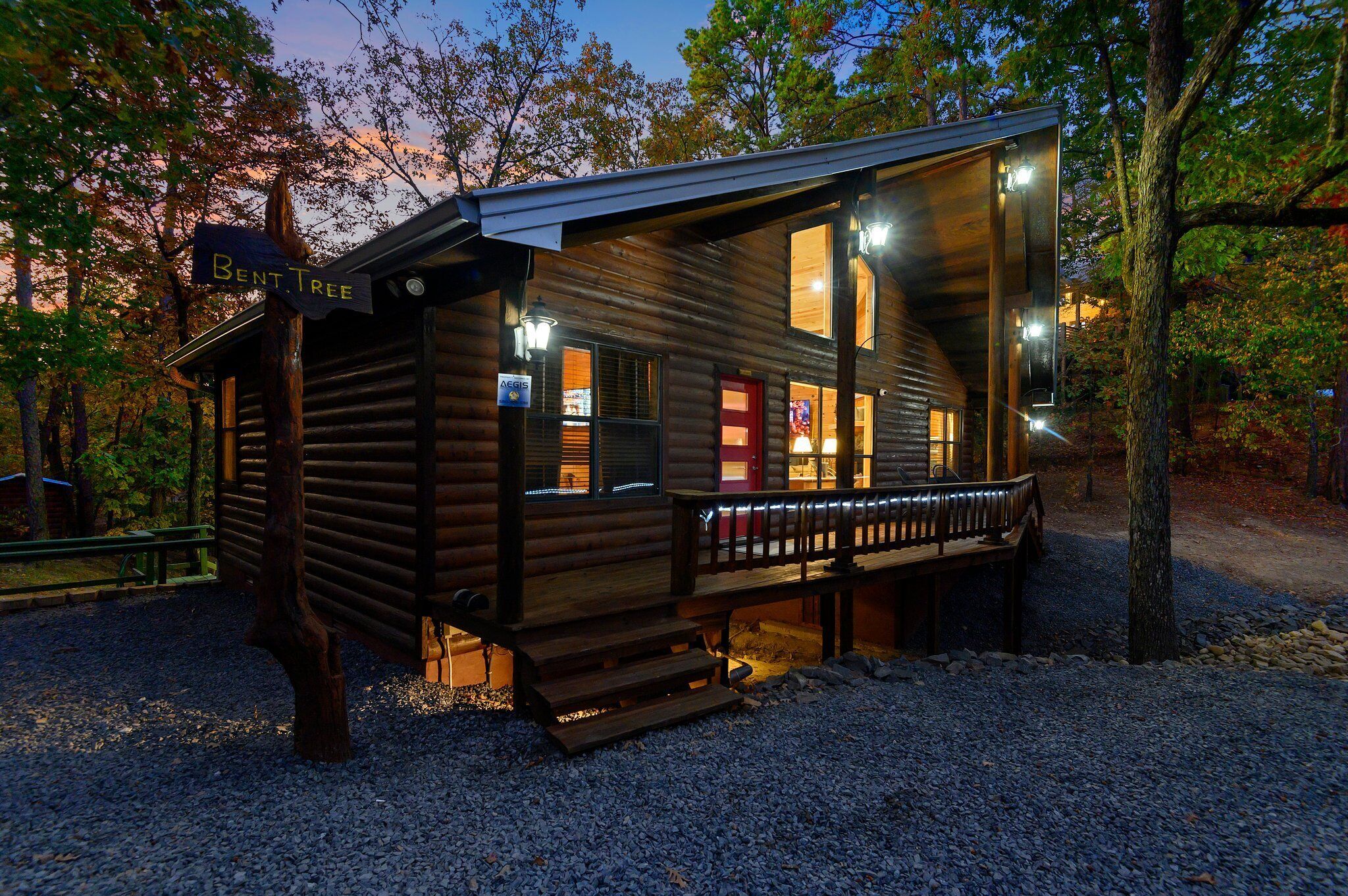 A rustic cabin with a wooden exterior, a porch, and a sign that reads "Bent Tree."