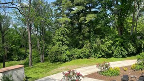 Un sendero pavimentado que atraviesa un jardín ajardinado con una zona de estar y un cobertizo pequeño.