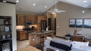 Una cocina moderna con armarios de madera, una isla central y taburetes de bar.