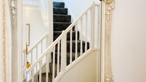A staircase with ornate white railings and a decorative frame. - Ashfield Boutique Stays (Altrincham)